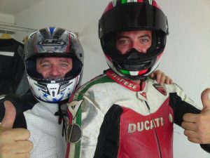 Zwei Motorradfahrer in einer Box auf der Rennstrecke